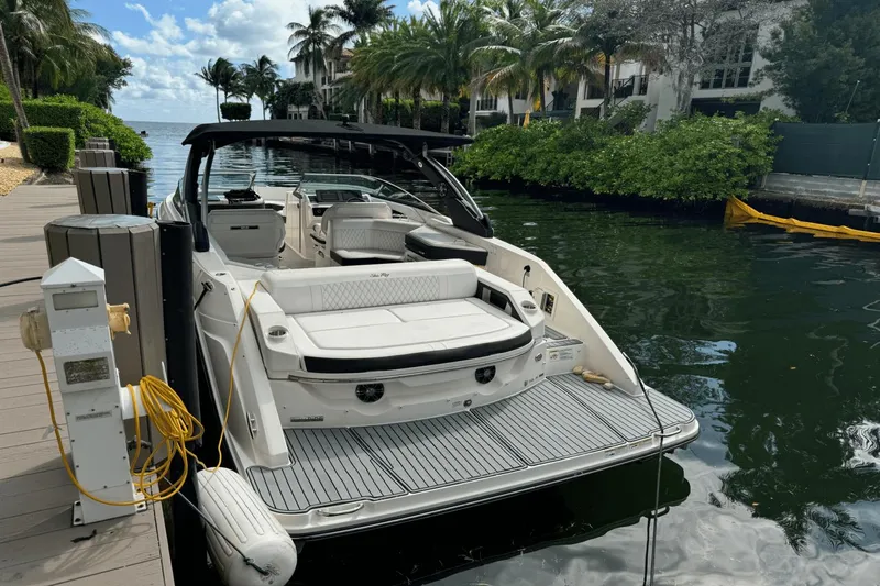  Yacht Photos Pics 2019 Sea Ray 310 SLX docked by a lush, tropical waterfront.