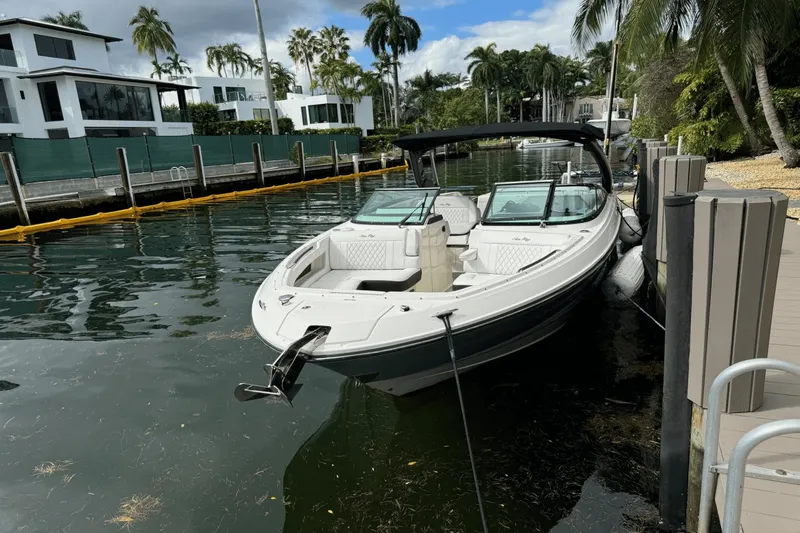  Yacht Photos Pics 2019 Sea Ray 310 SLX boat docked by waterfront homes with palm trees.