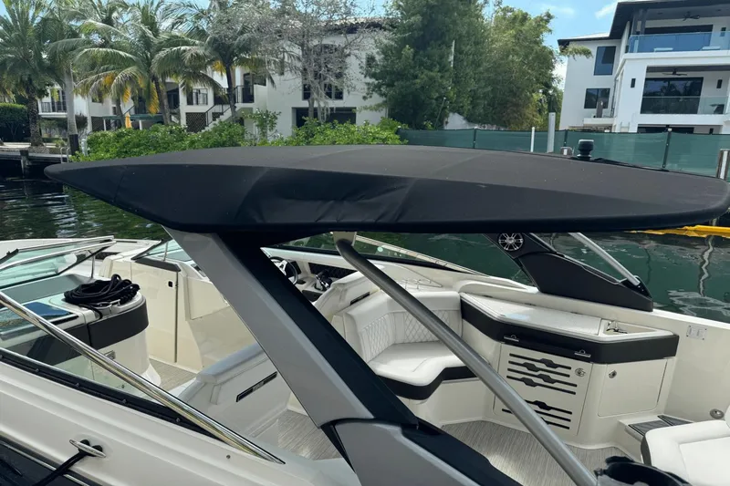  Yacht Photos Pics 2019 Sea Ray 310 SLX boat with black canopy, docked near waterfront homes.