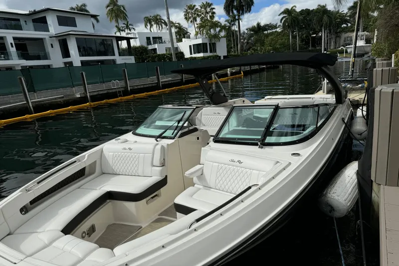  Yacht Photos Pics 2019 Sea Ray 310 SLX boat docked by waterfront homes, featuring sleek design and luxurious seating.