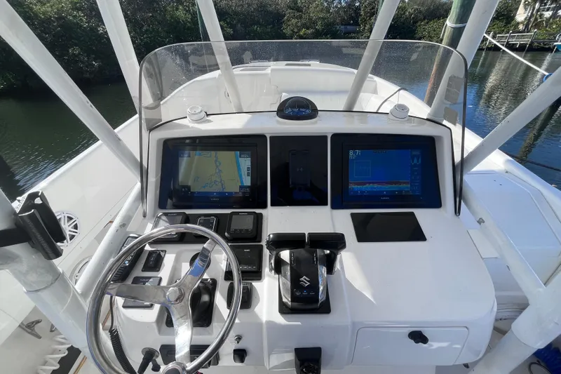  Yacht Photos Pics 2008 Intrepid 370 Cuddy helm with navigation screens and steering wheel, docked by water.