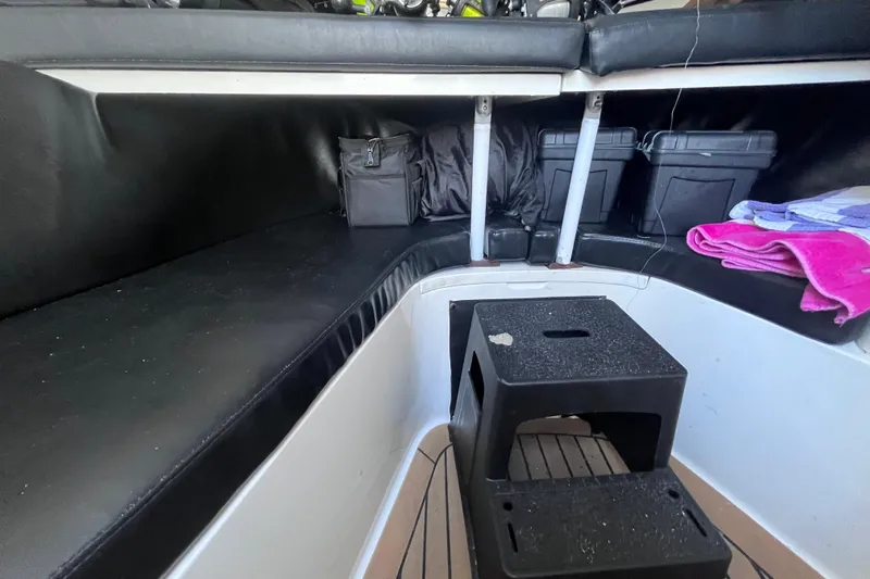  Yacht Photos Pics 2008 Intrepid 370 Cuddy interior with black seating, storage boxes, and a small step stool.