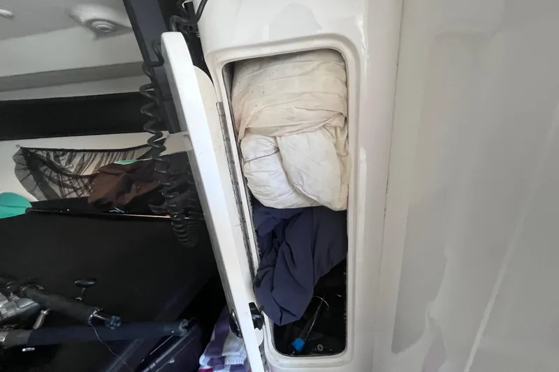 Yacht Photos Pics Storage compartment in a 2008 Intrepid 370 Cuddy boat, filled with bedding and clothes.