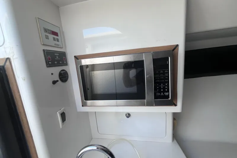  Yacht Photos Pics Microwave in 2008 Intrepid 370 Cuddy boat interior, featuring control panels and sink.