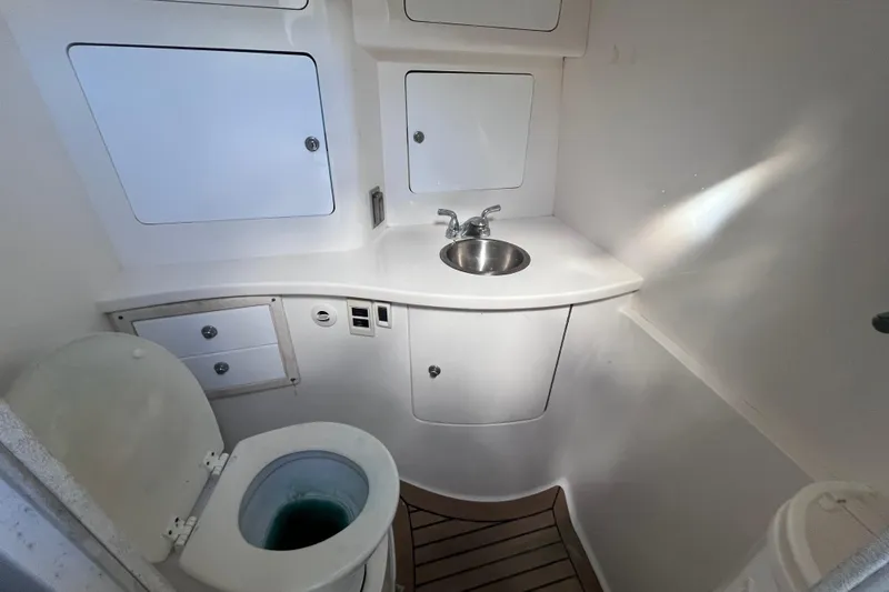  Yacht Photos Pics 2008 Intrepid 370 Cuddy boat bathroom with toilet, sink, and storage cabinets.