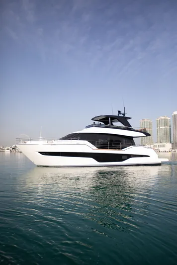  Yacht Photos Pics 2024 Cranchi Sessantasette 67 yacht on calm water with city skyline.