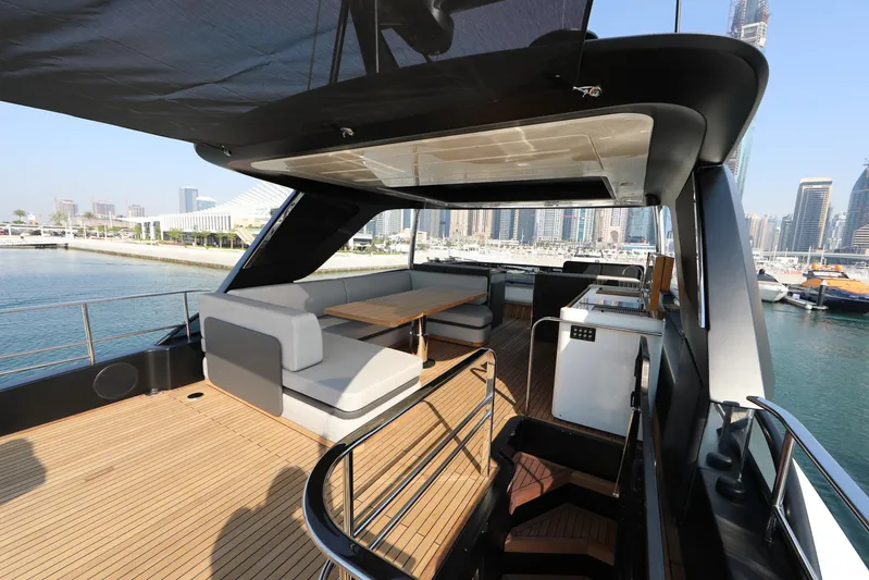  Yacht Photos Pics Luxury deck of 2024 Cranchi Sessantasette 67 yacht with modern seating and cityscape view.