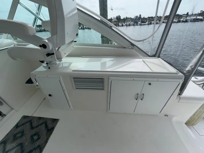 Land Ho Yacht Photos Pics 2007 Cabo 40 Express boat interior with storage cabinets and seating, docked by the water.