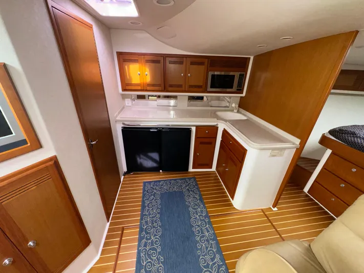 Land Ho Yacht Photos Pics 2007 Cabo 40 Express yacht interior with kitchenette, wooden cabinets, and flooring.