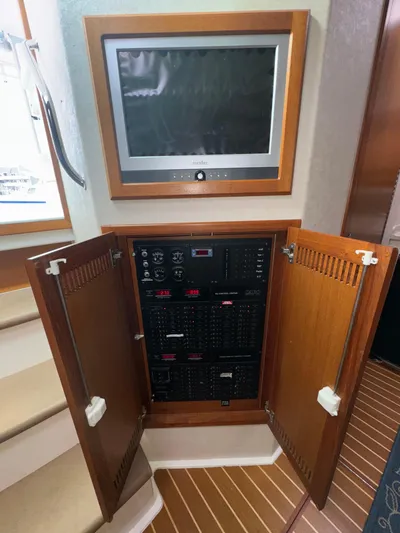 Land Ho Yacht Photos Pics 2007 Cabo 40 Express electrical panel with wooden cabinet and mounted screen.