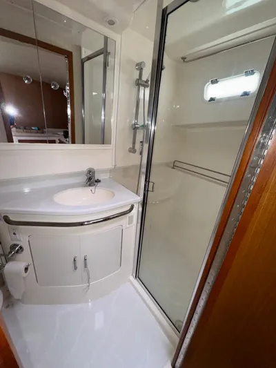 Land Ho Yacht Photos Pics 2007 Cabo 40 Express yacht bathroom with sink, mirror, and shower.