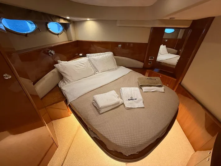  Yacht Photos Pics Luxurious cabin interior of 2009 Princess V58 yacht with cozy bed and elegant wood finish.