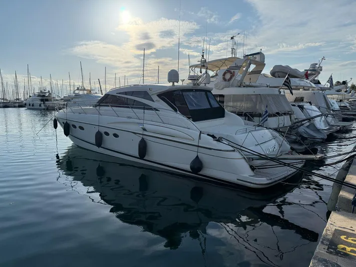  Yacht Photos Pics 2009 Princess V58 yacht docked at marina, calm water, clear sky.