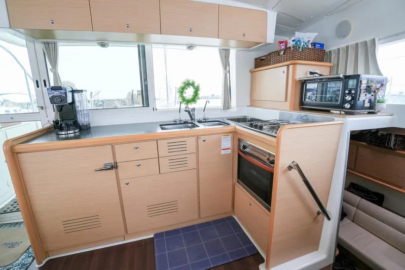 Bleu Lagoon Yacht Photos Pics Modern kitchen interior of 2012 Lagoon 421 yacht with appliances and wooden cabinetry.