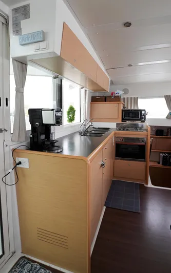 Bleu Lagoon Yacht Photos Pics Modern kitchen interior of 2012 Lagoon 421 catamaran with appliances and wood cabinetry.