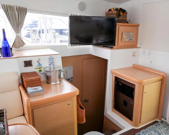 Bleu Lagoon Yacht Photos Pics Interior of 2012 Lagoon 421 yacht with TV, wooden cabinetry, and nautical decor.