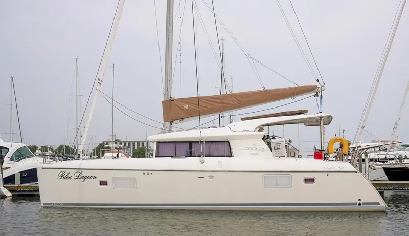 Bleu Lagoon Yacht Photos Pics 2012 Lagoon 421 catamaran docked in marina, featuring sleek design and spacious deck.