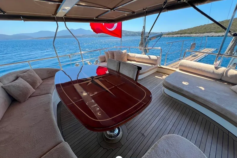 Cİca Sultan Yacht Photos Pics Luxurious Ark Yat 24M yacht deck with elegant seating, Turkish flag, and scenic ocean view.