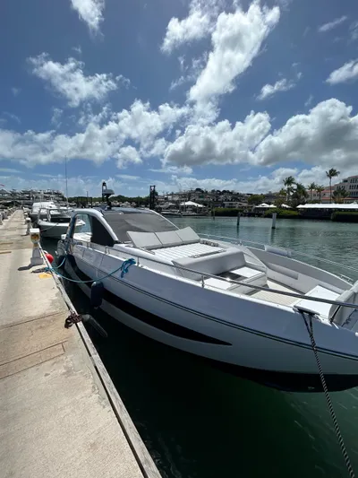  Yacht Photos Pics 2024 Azimut Verve 48 yacht docked under a bright blue sky with scattered clouds.