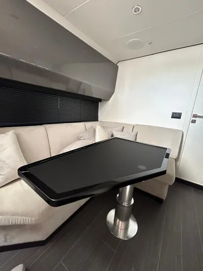  Yacht Photos Pics 2024 Azimut Verve 48 yacht interior with sleek black table and beige seating.
