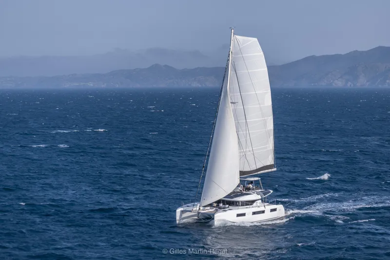  Yacht Photos Pics Sailing Lagoon 51 Owners version 2026 catamaran on open sea with distant mountains.