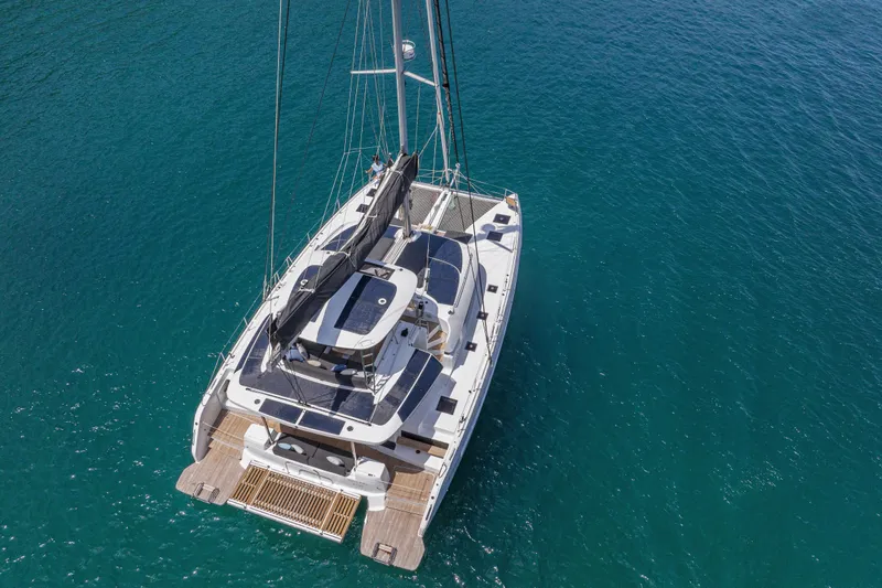  Yacht Photos Pics Aerial view of 2026 Lagoon 51 Owners version catamaran on clear blue water.
