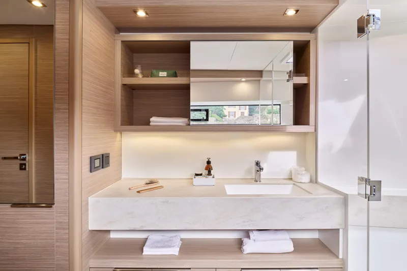  Yacht Photos Pics Modern bathroom interior in 2026 Lagoon 51 Owners version yacht, featuring sleek wood finishes.