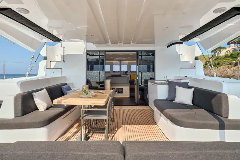  Yacht Photos Pics Luxurious 2026 Lagoon 51 Owners version yacht interior with elegant seating and dining area.