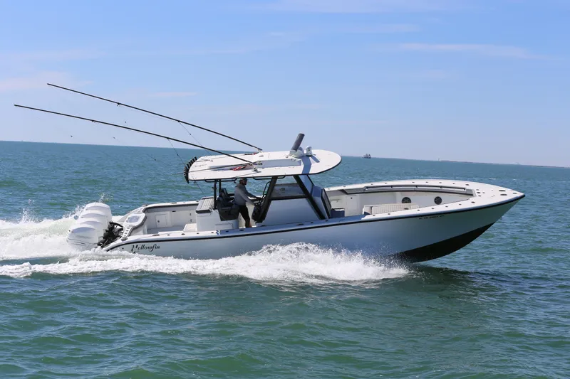  Yacht Photos Pics 2018 Yellowfin 39 boat cruising on open water, equipped with fishing rods and triple engines.