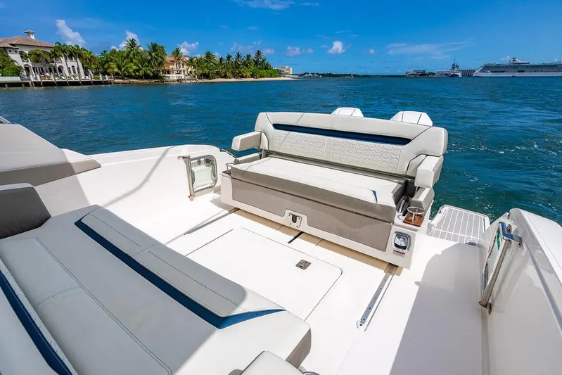 Let's Go Yacht Photos Pics Luxurious seating on 2023 Tiara Yachts 34 LS, overlooking serene waterfront and distant cruise ships.