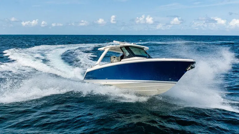 Let's Go Yacht Photos Pics 2023 Tiara Yachts 34 LS cruising on open ocean, creating dynamic water spray.