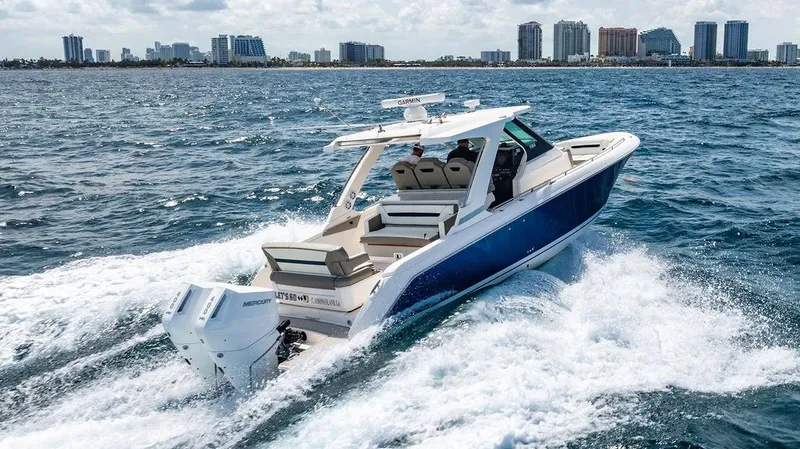Let's Go Yacht Photos Pics 2023 Tiara Yachts 34 LS cruising on ocean with city skyline in background.