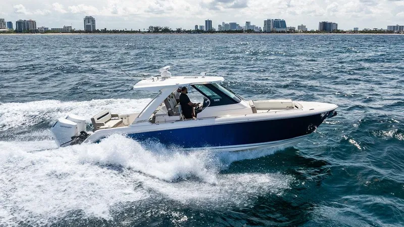 Let's Go Yacht Photos Pics 2023 Tiara Yachts 34 LS cruising on open water near city skyline.