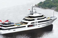 Luxurious 2028 AlCustom yacht with helicopter, pool, and modern design cruising near lush coastline.