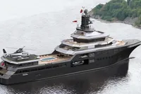 Luxurious 2028 AlCustom yacht with helipad and pool cruising near lush coastline.