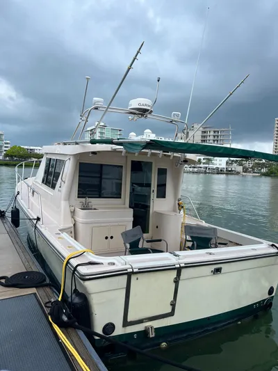 Yacht Photos Pics 2004 Albin 35 Tournament Express boat docked by the waterfront under cloudy skies.
