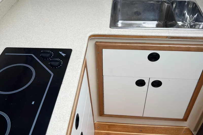  Yacht Photos Pics 2004 Albin 35 Tournament Express kitchen with stove, sink, and storage cabinets.