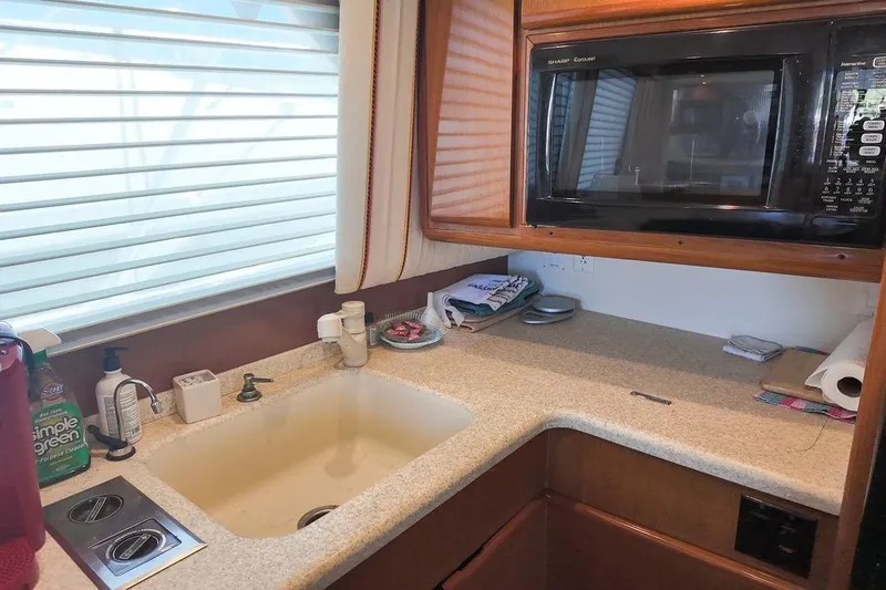 Coming To Fort Lauderdale By Nov. 3 Yacht Photos Pics 1999 Viking Cockpit Sports Yacht kitchen with sink, microwave, and countertop essentials.