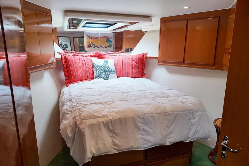 Coming To Fort Lauderdale By Nov. 3 Yacht Photos Pics Cozy bedroom in 1999 Viking Cockpit Sports Yacht with vibrant decor and wooden cabinetry.