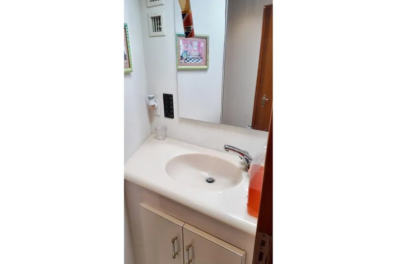 Coming To Fort Lauderdale By Nov. 3 Yacht Photos Pics Bathroom sink area in a 1999 Viking Cockpit Sports Yacht, featuring a mirror and faucet.