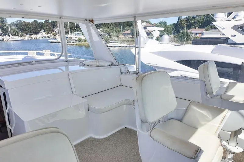 Coming To Fort Lauderdale By Nov. 3 Yacht Photos Pics 1999 Viking Cockpit Sports Yacht interior with white seating and marina view.