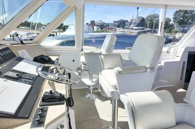 Coming To Fort Lauderdale By Nov. 3 Yacht Photos Pics 1999 Viking Cockpit Sports Yacht interior with white captain chairs and control panel.