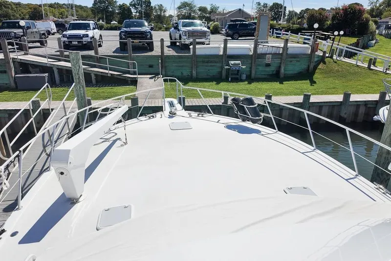 Coming To Fort Lauderdale By Nov. 3 Yacht Photos Pics 1999 Viking Cockpit Sports Yacht docked, with parked vehicles in the background.