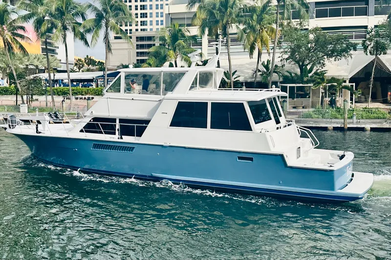 Coming To Fort Lauderdale By Nov. 3 Yacht Photos Pics 1999 Viking Cockpit Sports Yacht cruising on a tropical waterway with palm trees.