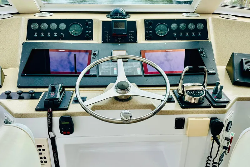 Coming To Fort Lauderdale By Nov. 3 Yacht Photos Pics Cockpit of a 1999 Viking Sports Yacht with steering wheel and navigation controls.