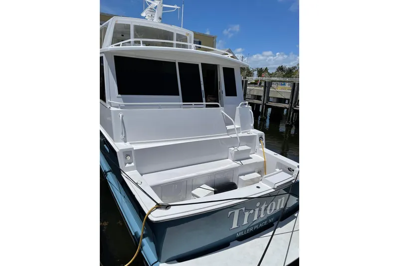 Least Expensive In The World Yacht Photos Pics 1999 Viking Cockpit Sports Yacht docked, rear view with seating and steps, sunny day.