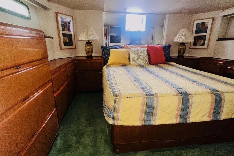 Least Expensive In The World Yacht Photos Pics 1999 Viking Cockpit Sports Yacht bedroom with cozy bed, wooden cabinets, and decorative lamps.