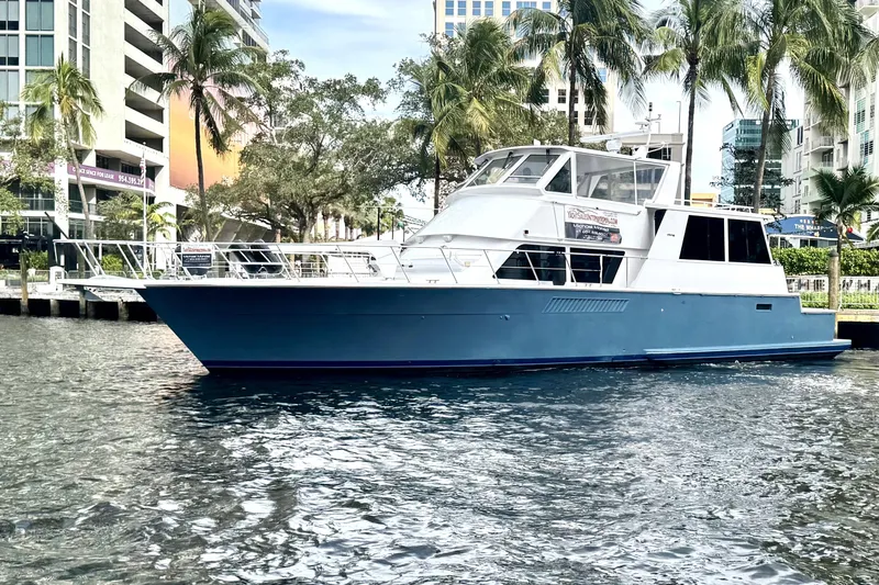 Least Expensive In The World Yacht Photos Pics 1999 Viking Cockpit Sports Yacht docked near palm trees and modern buildings.