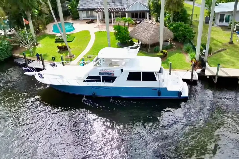 Triton Yacht Photos Pics 1999 Viking Cockpit Sports Yacht docked by a luxurious waterfront property with pool.