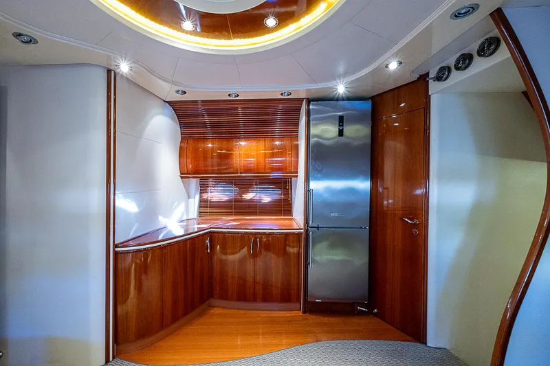  Yacht Photos Pics Luxurious kitchen interior of 2000 Pershing 65 Limited yacht with wood finish and modern appliances.